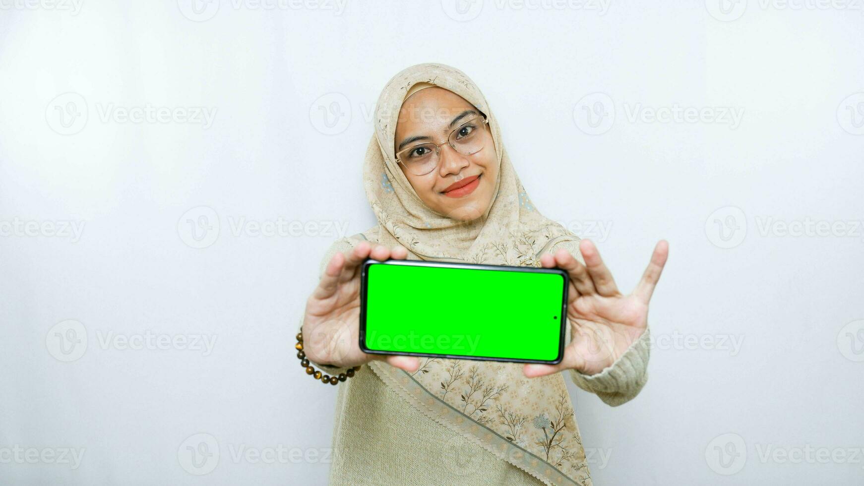 young asian woman showing copy space on her phone screen. Isolated over white background photo