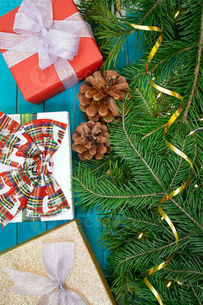 Festive background. Gift boxes with bows with fir branches and lights. View from above. Christmas, New Year, birthday, holidays, sale, flat lay. Greeting card, banner, poster. Vertical, horizontal photo