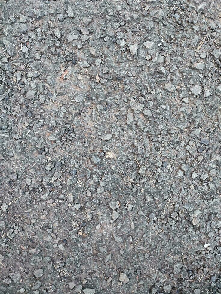 asfalto áspero y rocoso grunge superficie, textura fondo, gris pavimentado la carretera foto