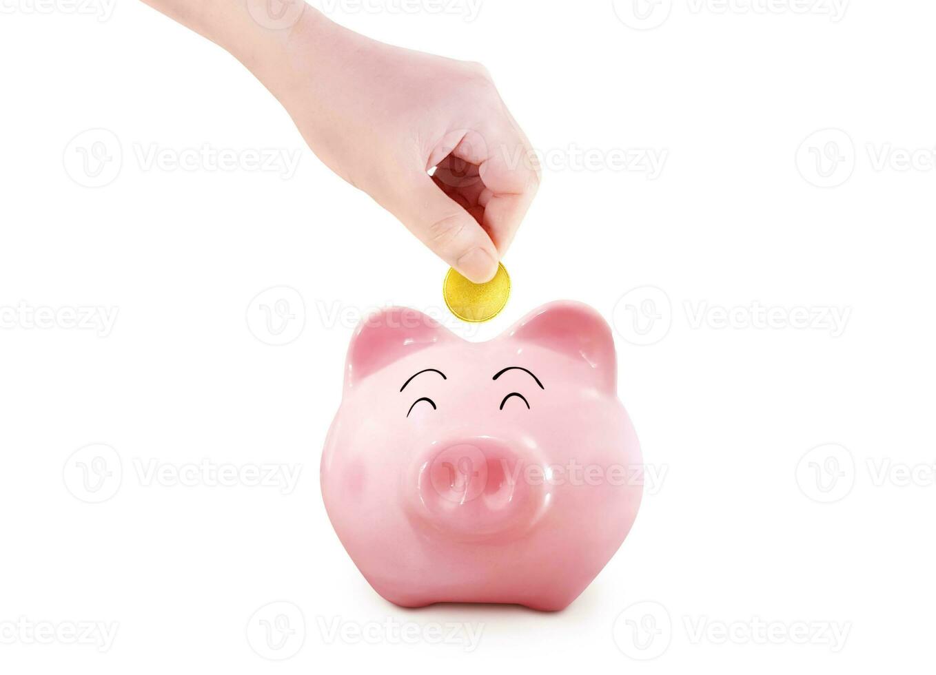 Hand puts gold coins into a piggy bank on a white background. photo