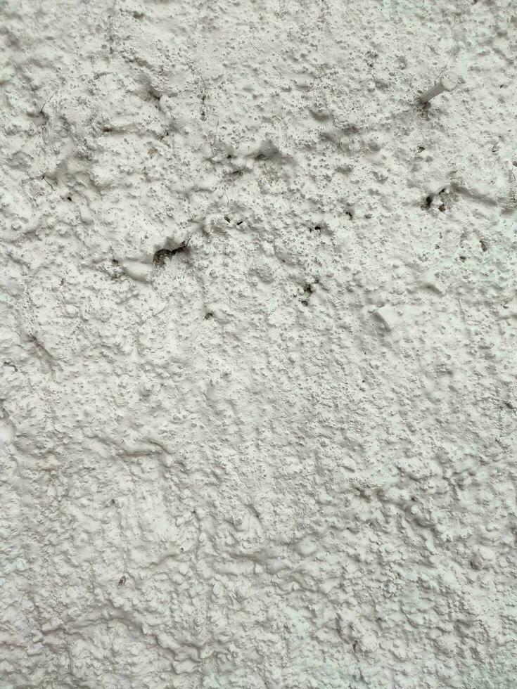 el textura y antecedentes de el blanco cemento Roca pared es áspero y ondulado foto