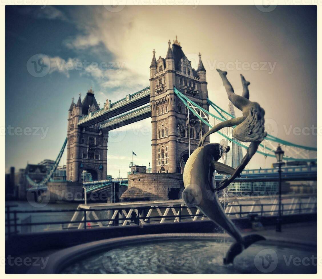 Iconic View of Tower Bridge with Dolphin Statue and Young Mermaid, London, UK photo