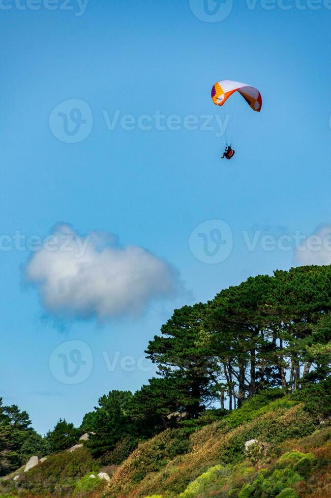 Paragliding Over Brittany Coastline Summer Blue Sky and Sea photo