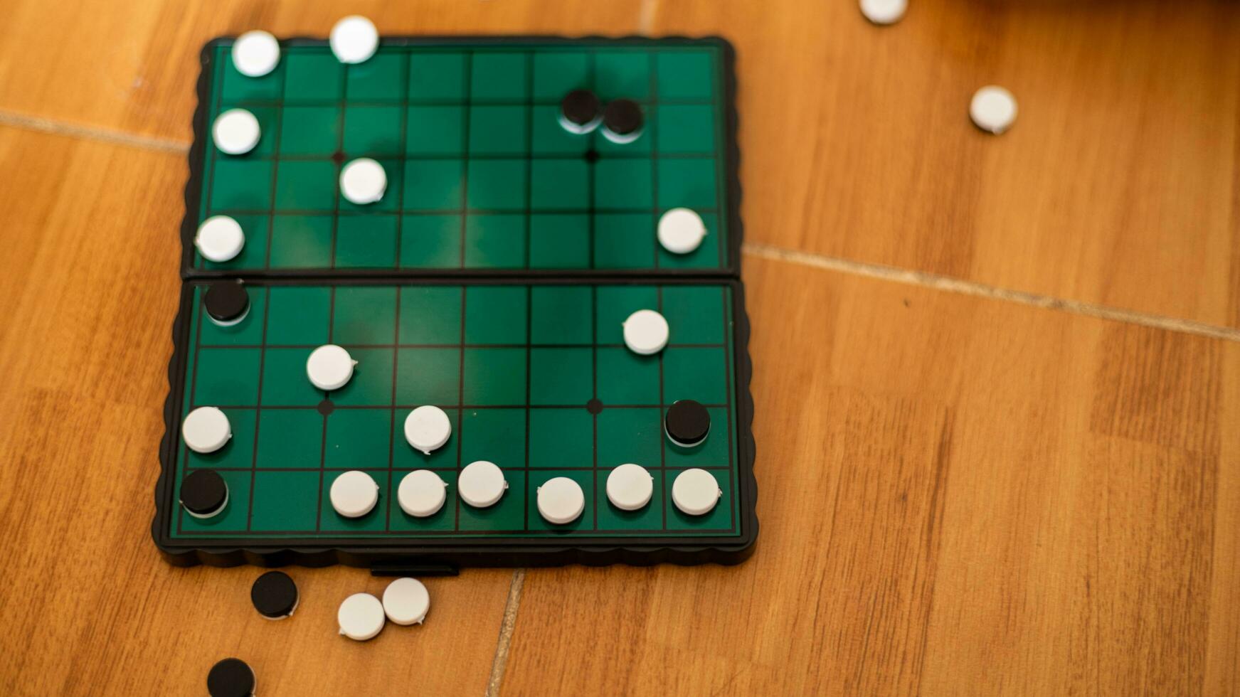 White and black stones are placed on a wooden board for playing Go. photo
