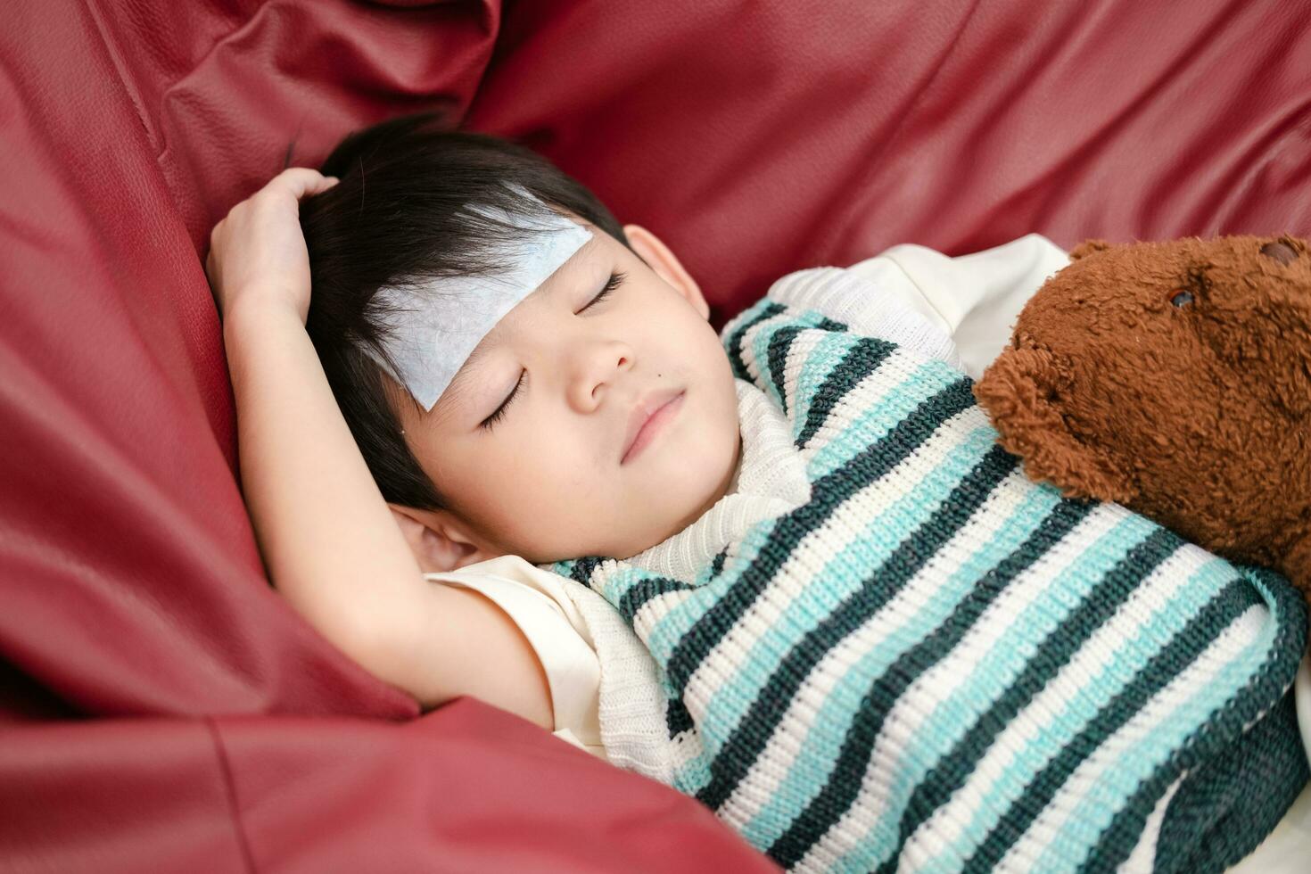 asiático chico ella estaba enfermo y tenido un fiebre reduciendo parche en su frente. ella estaba acostado en el cama. foto