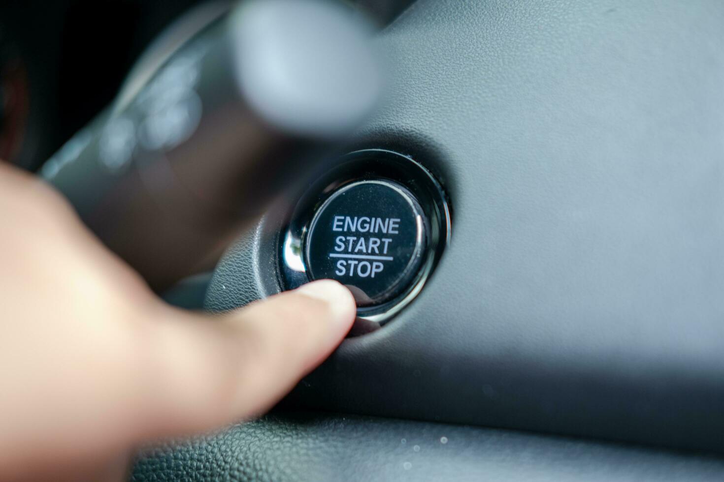 Male finger pressing engine start stop button photo