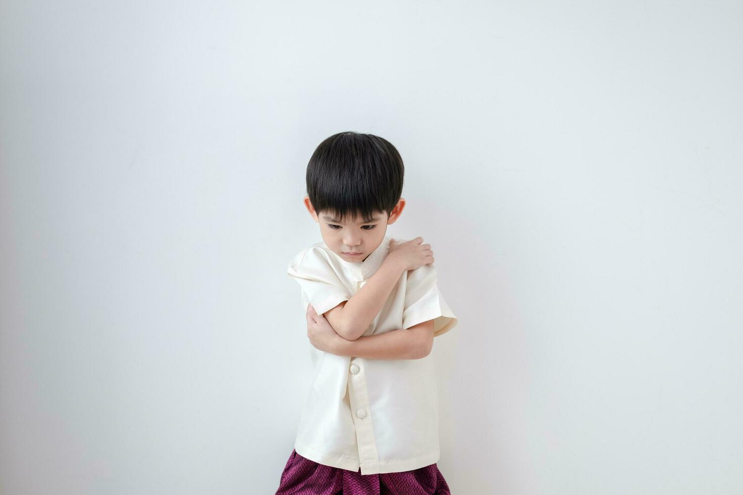 Asian boy Wearing traditional Thai clothing, standing with arms crossed. on a white background photo