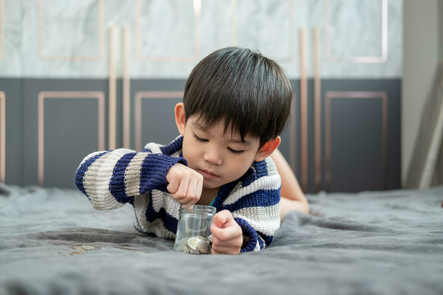 Asian boy happily counting coins to save money photo