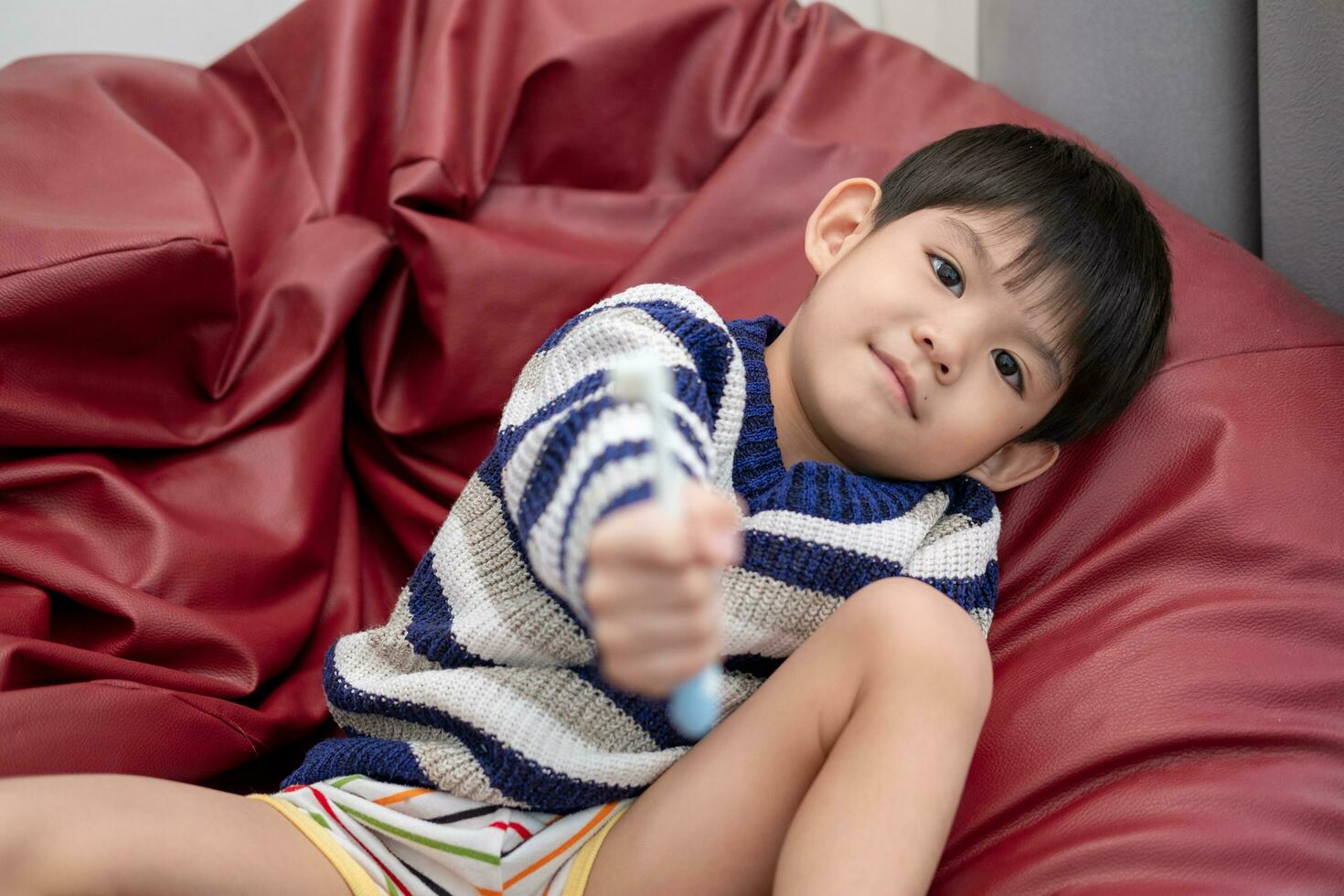 Asian boy brushing his teeth on the living room photo