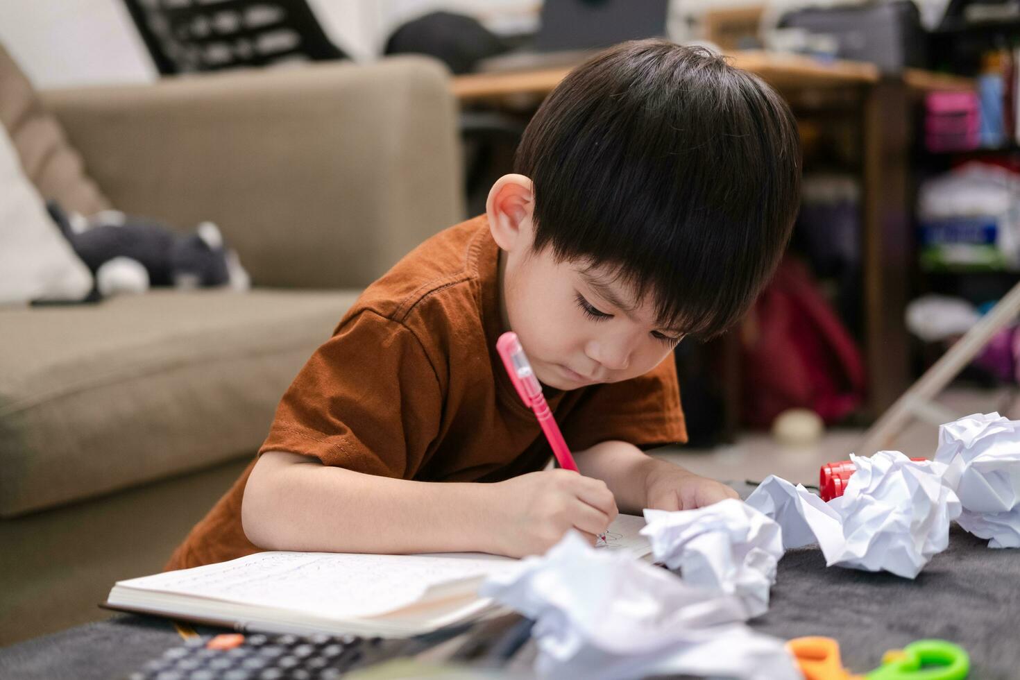 Asian boy drawing on table And there was a piece of paper left on the table. photo