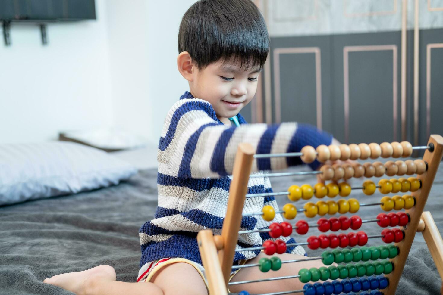 Asian boy playing with toys on the bed photo