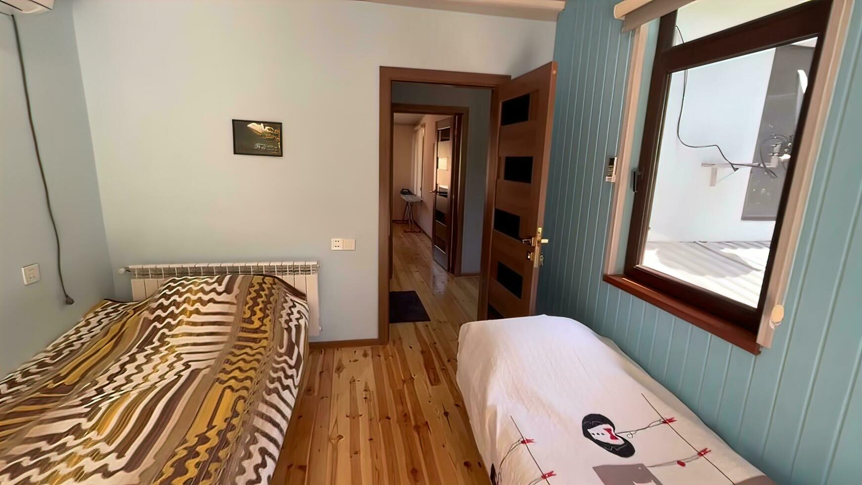 Interior of a hotel room with a double bed and wooden floor photo