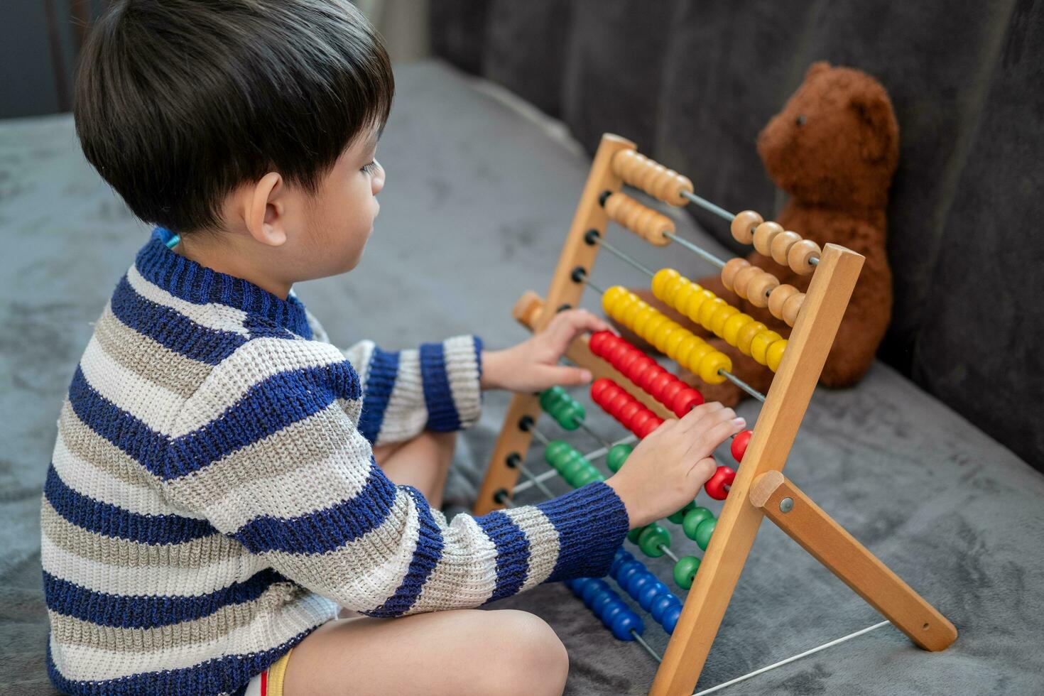 Asian boy playing with toys on the bed photo