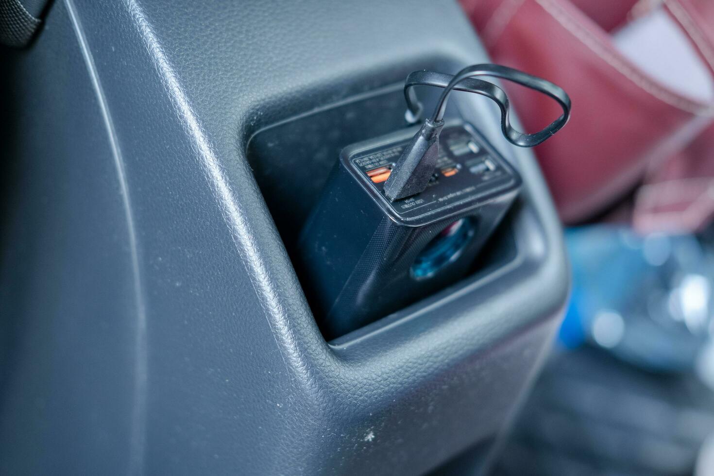 Power bank with charging cable plugged in Store in the back seat pocket of your car. photo