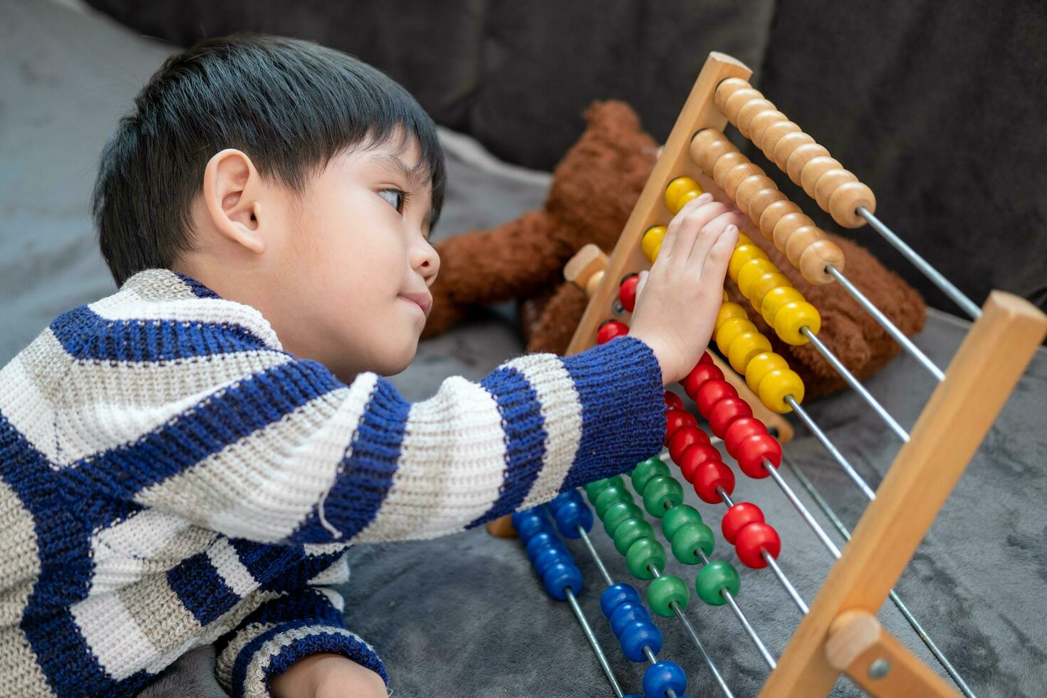 Asian boy playing with toys on the bed photo