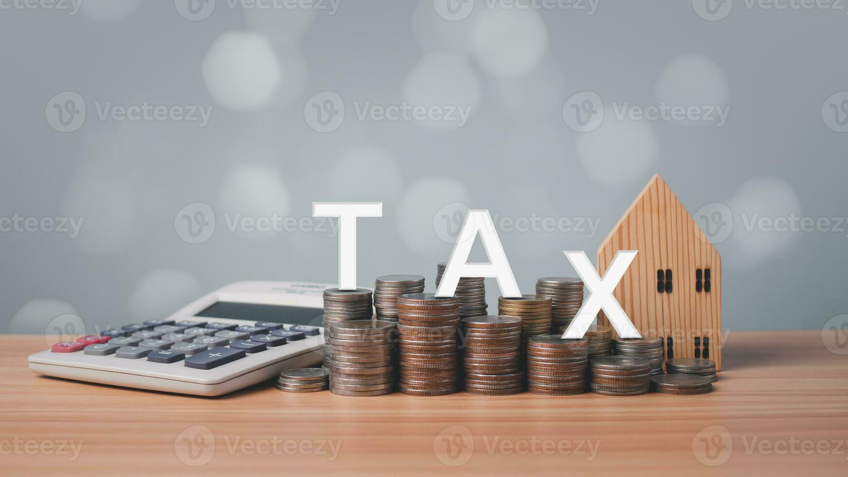 Model wooden house, calculator and coins lined up on wooden floor on white background. Concepts of mortgage, loand, transfer, finance, savings and investment. Real estate tax concepts. photo