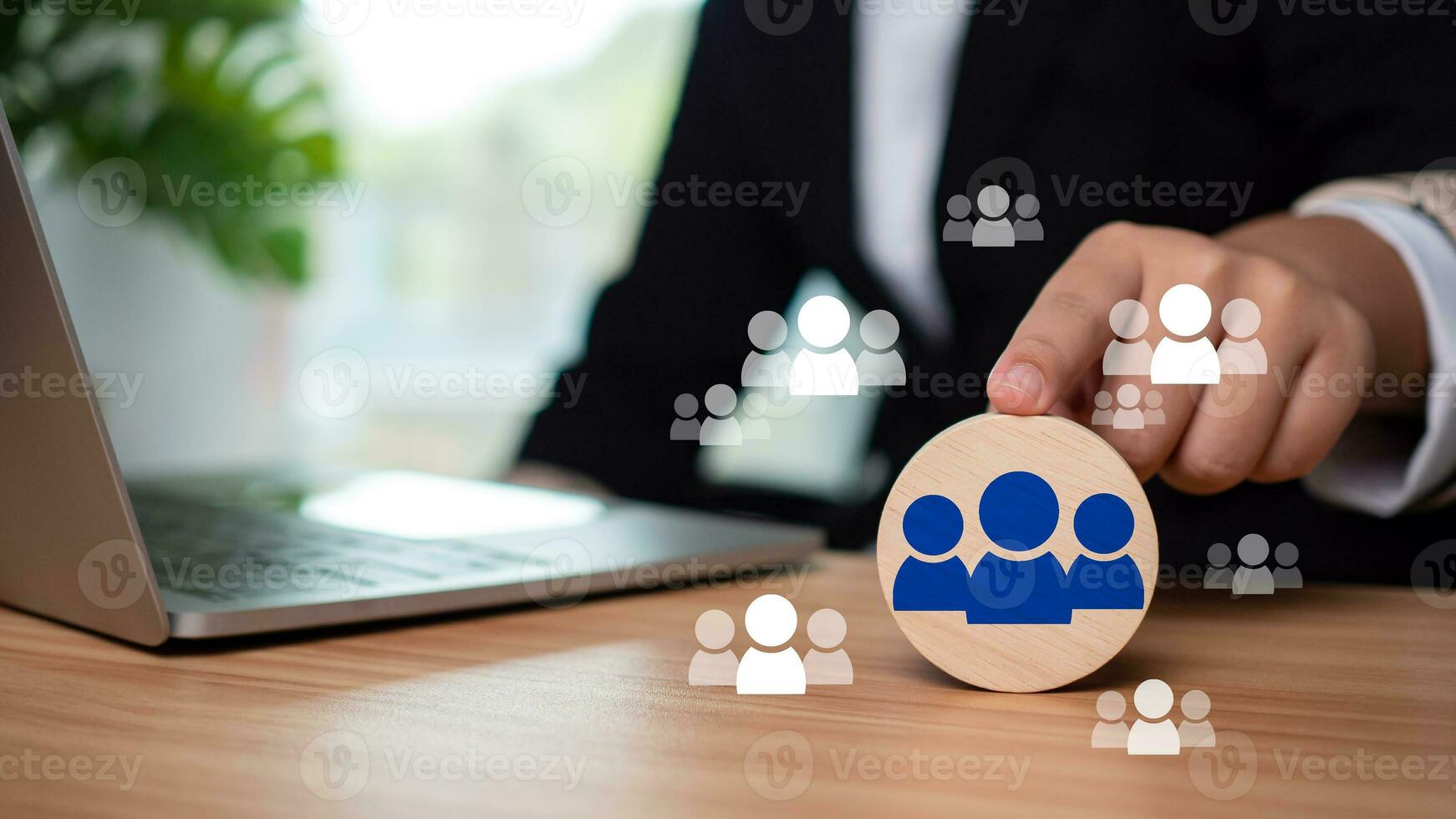 Businessman points finger at circular wooden plank to select business target audience and target customers photo