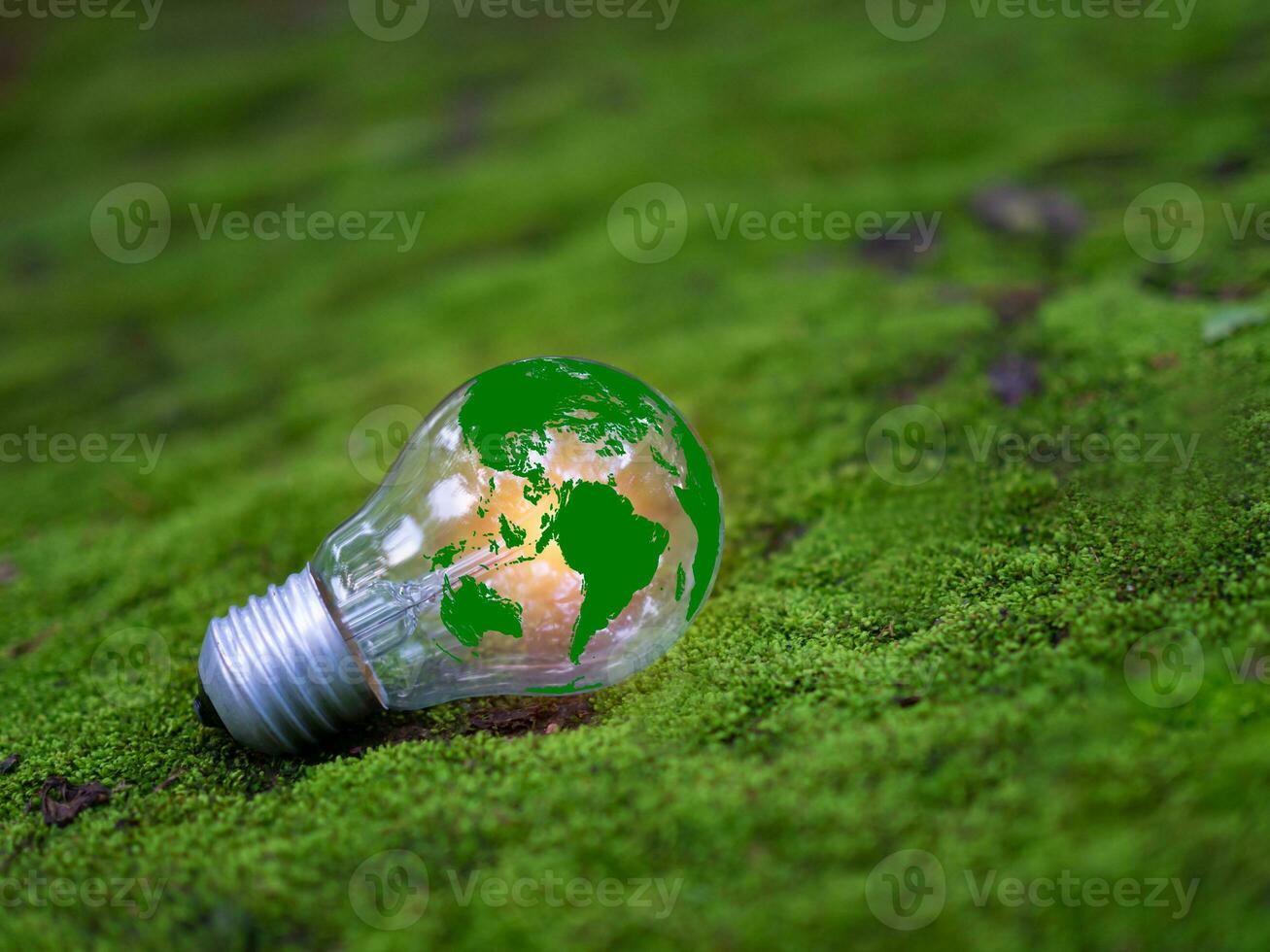 Concept of renewable energy, environmental protection, and sustainable renewable energy sources. Green world map on a light bulb set on a background with green moss. Green energy. photo