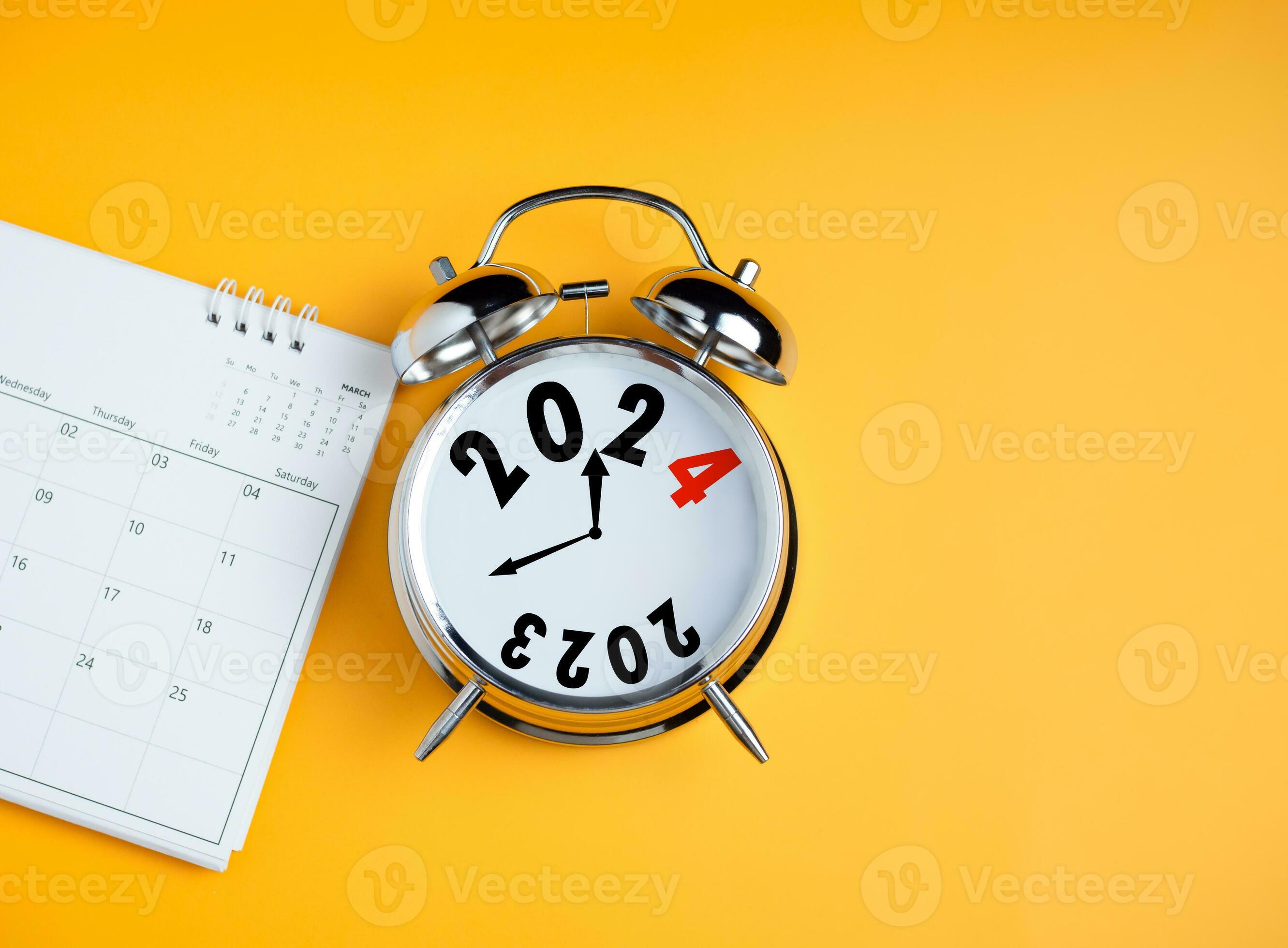 Closeup of calendar and clock alarm clock on yellow background with