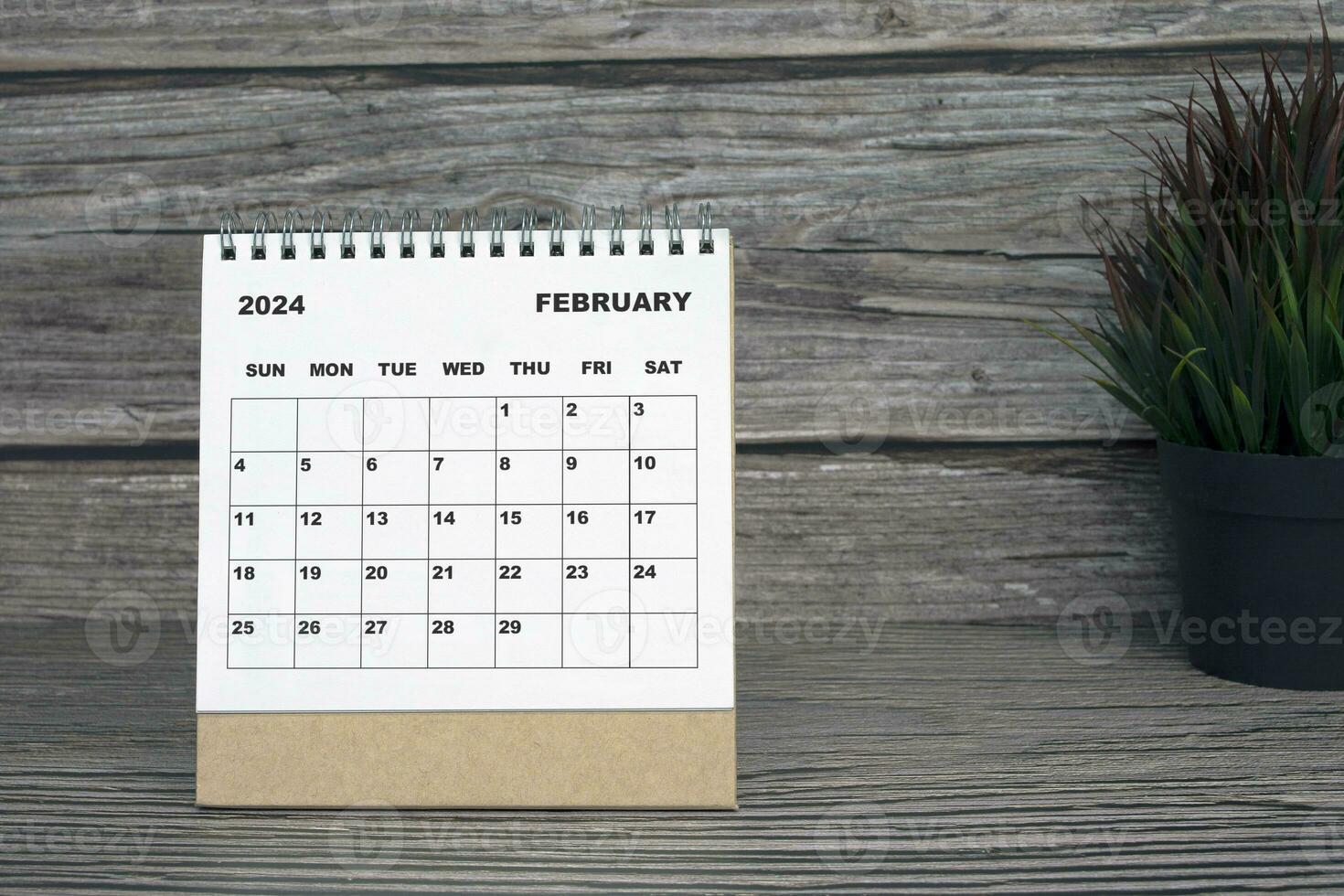 White February 2024 calendar on wooden desk. 2024 New Year Concept photo