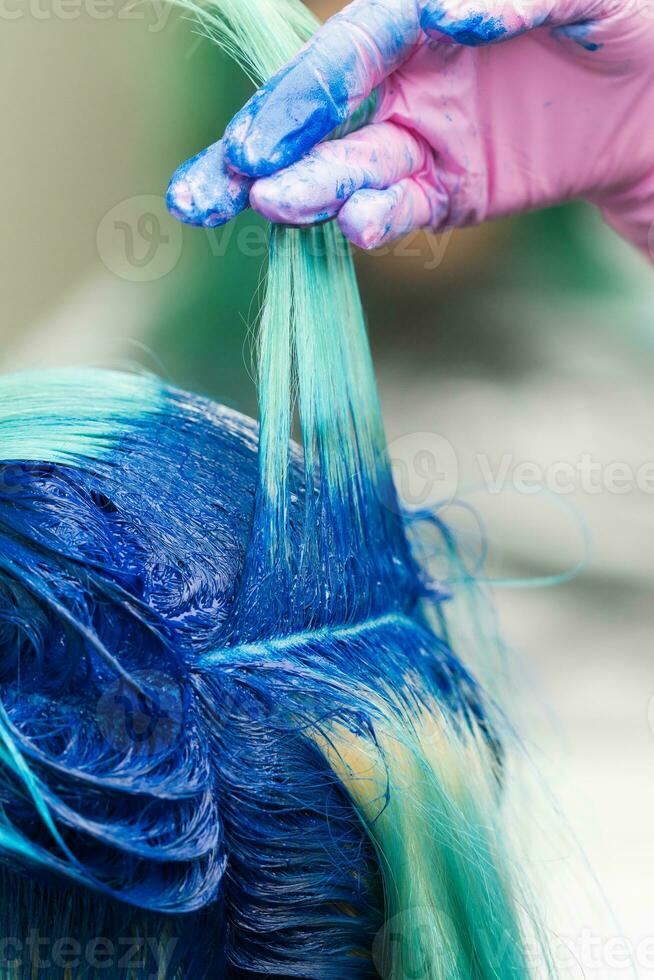 Hairdressers raise shock of blue hair of client hair dyeing coloring process photo