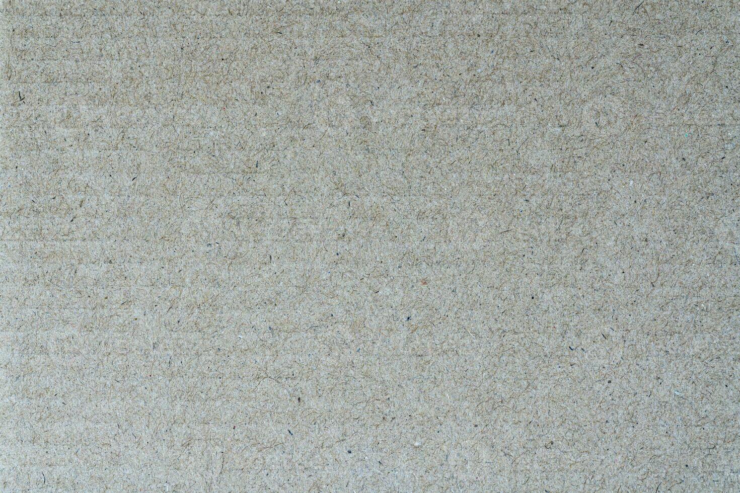 Light brown abstract background from sheet recycled cardboard. Closeup material pattern photo