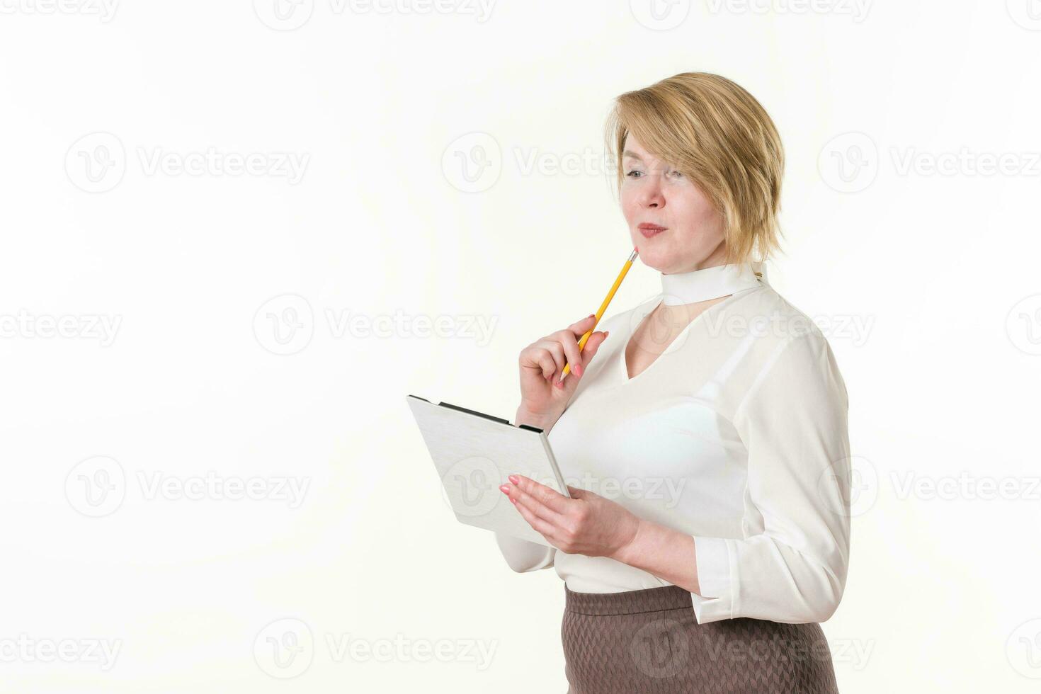 Thoughtful businesswoman with pencil, clipboard looking away. Experienced middle-aged business woman photo