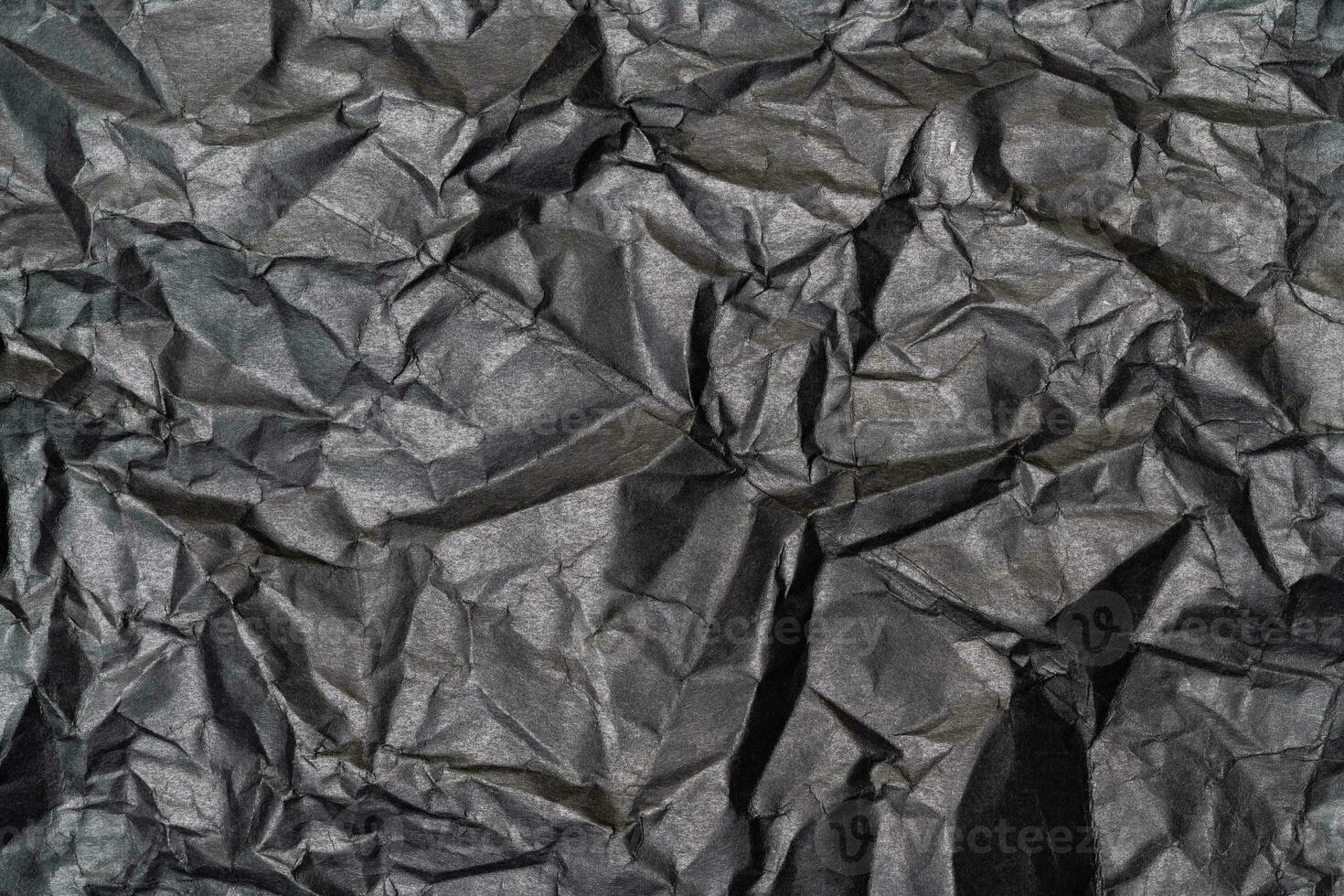 Close-up detail black color background from sheet of crumpled carton, abstract texture wrinkled cardboard material pattern background photo