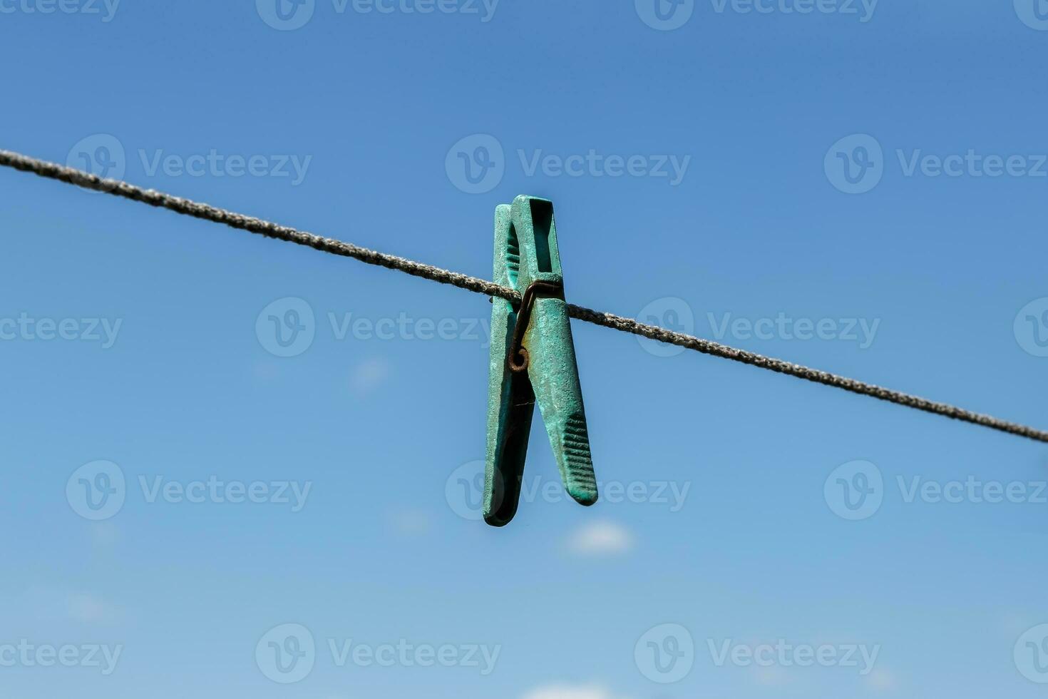 clothespin hanging on a clothesline with blue sky photo