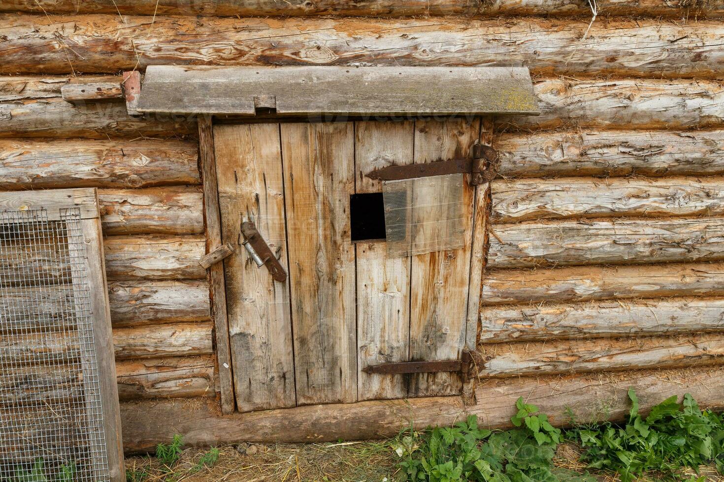 Animal stall. Closed door in a wooden barn. Entrance to the animal shed photo