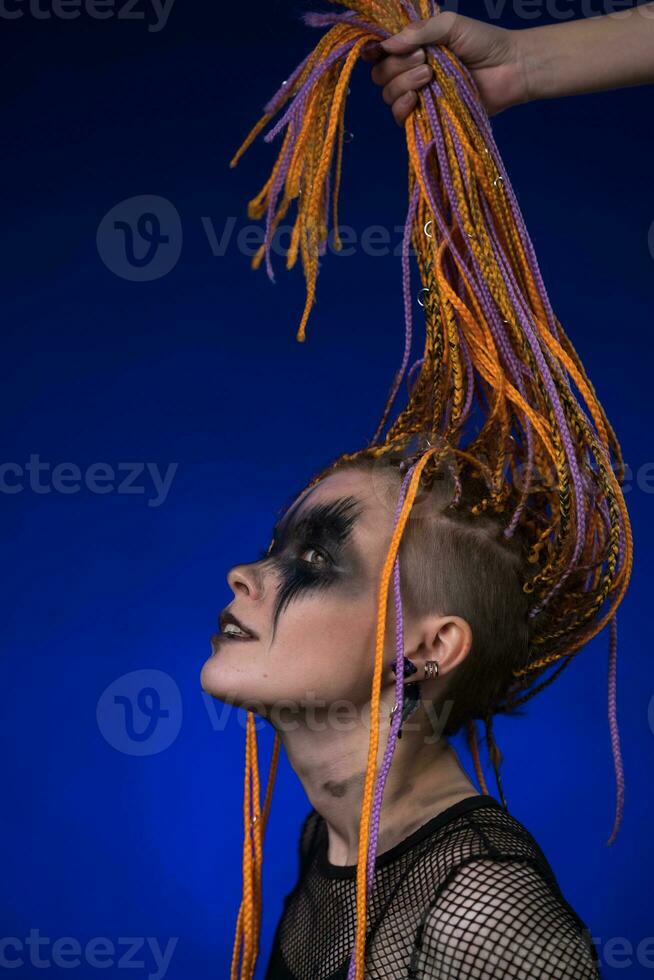 Informal young female with colored braids hairdo and spooky black stage  makeup painted on face 32500499 Stock Photo at Vecteezy