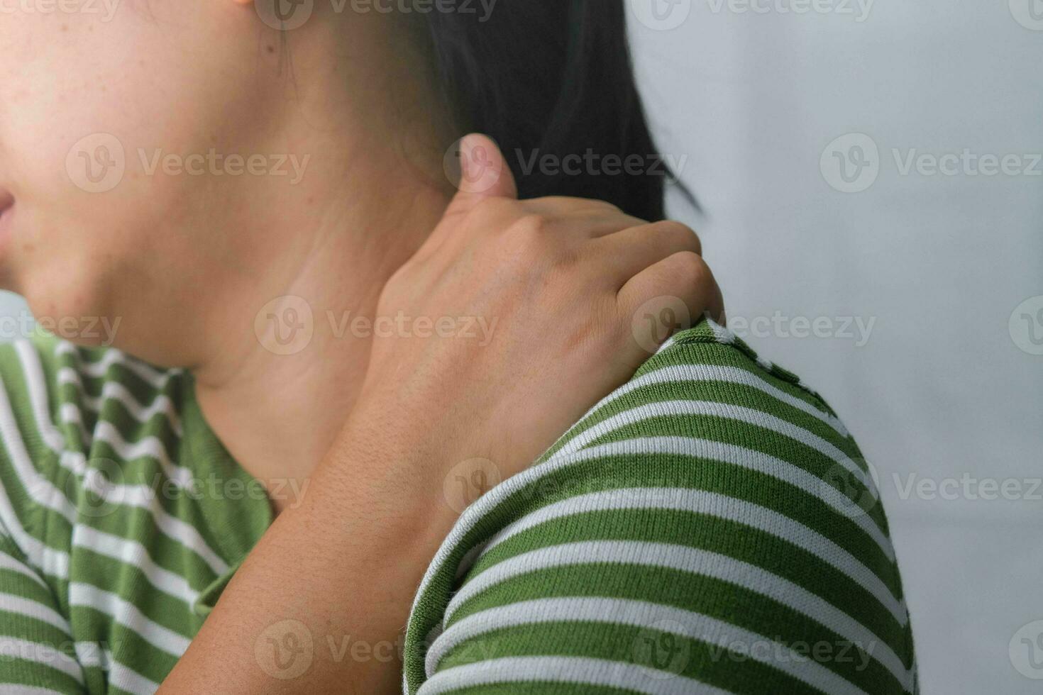 temperamental joven mujer participación su cuello. cansado mujer masajear rígido cuello, tirante músculos, agotado desde trabajar. Superior brazo dolor. cuidado de la salud y medicina concepto. foto