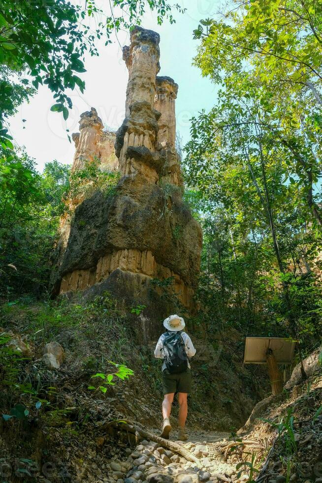Female geologist with backpack exploring nature trail in forest and analyzing rock or gravel. Researchers collect samples of biological materials. Environmental and ecology research. photo