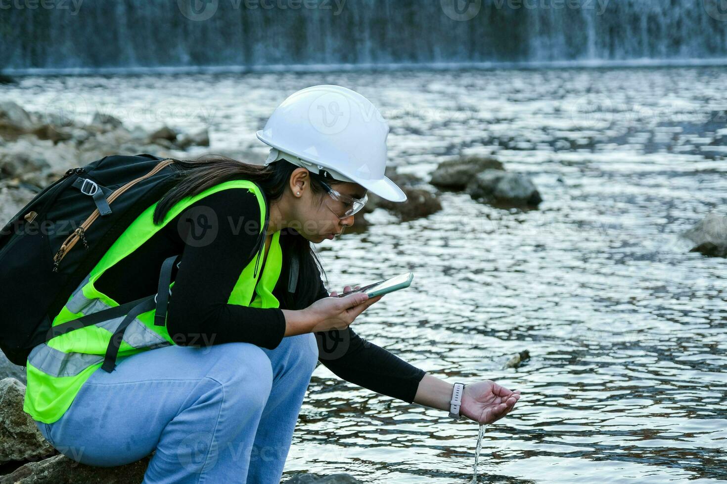 ambiental ingeniero usos un móvil teléfono a grabar agua análisis datos en represa. ambientalistas recoger agua muestras desde el represa a cheque para contaminación. agua y ecología concepto foto