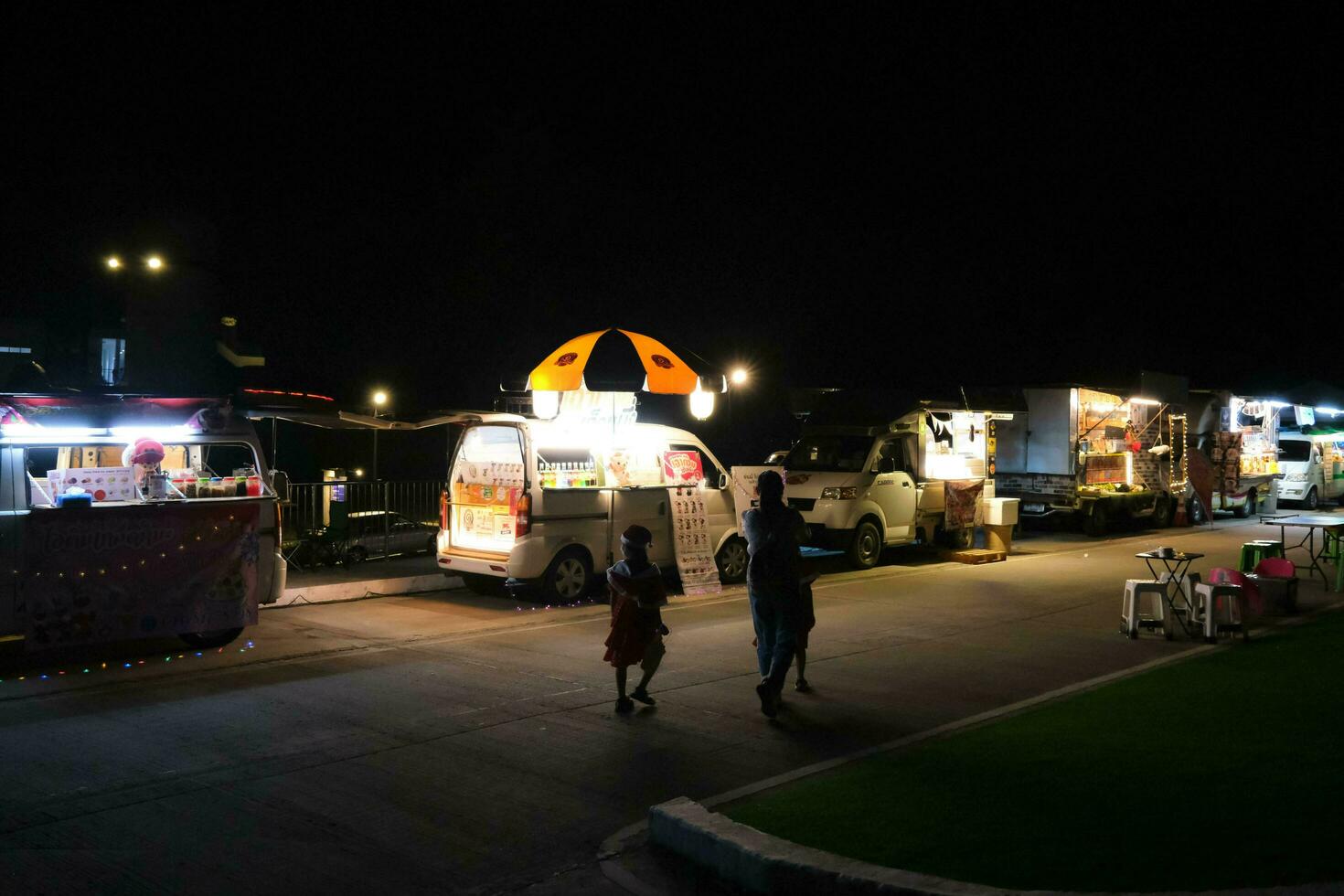 Mother and children are shopping at the night market. Happy family spending time together on vacation. photo