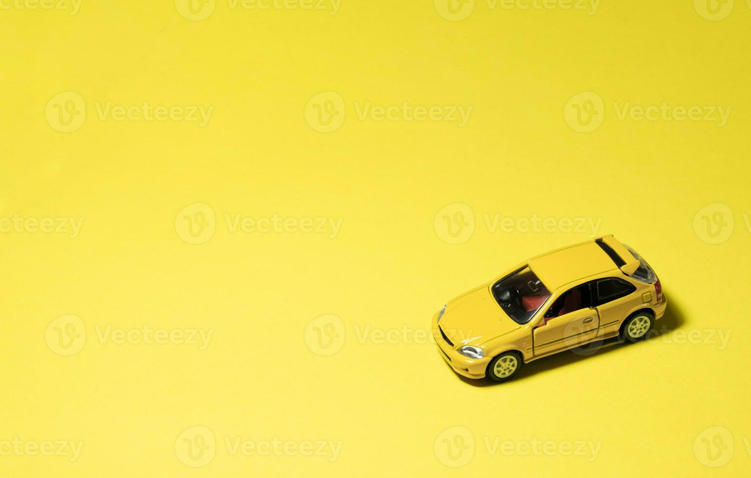 Yellow toy car isolated on yellow background. After some edits. photo