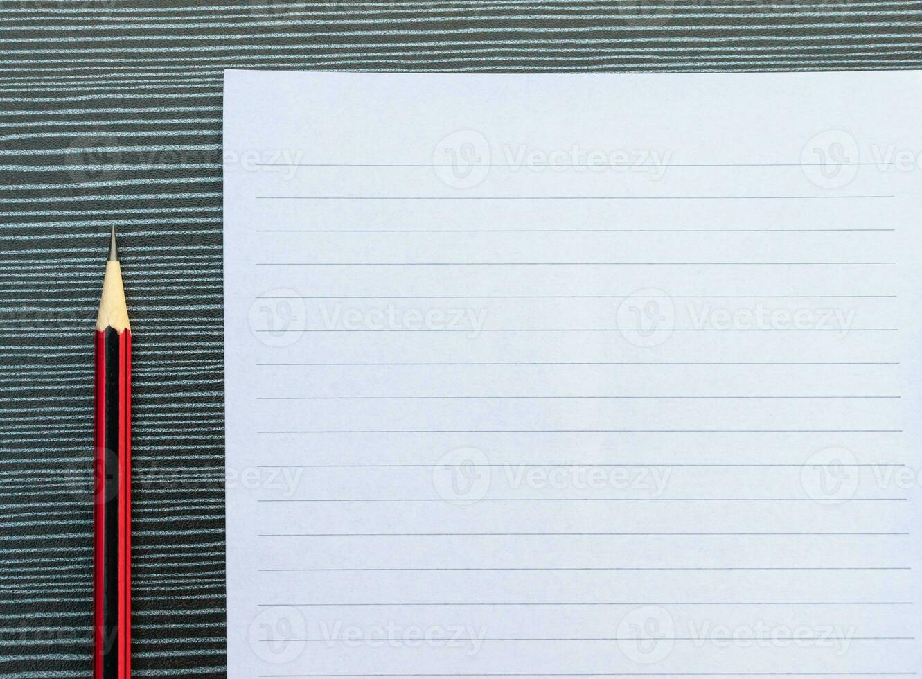 A pencil and a piece of paper on the table. After some edits. photo