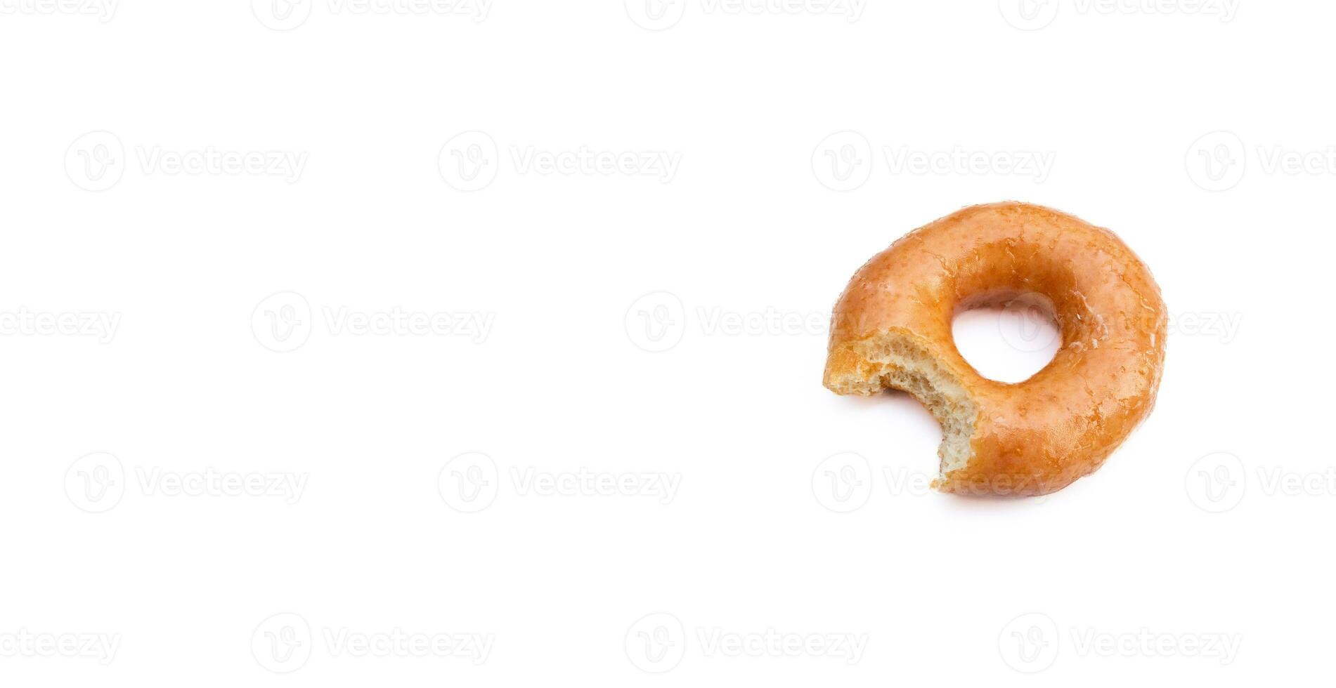 Bitten glazed donut isolated on white background. After some edits. photo