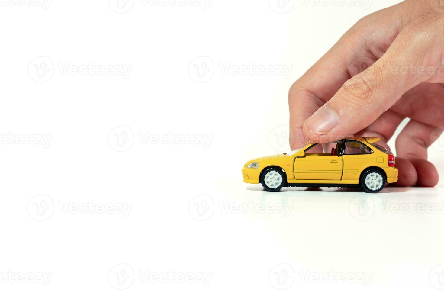 Hand holding a yellow toy car isolated on white background. After some edits. photo