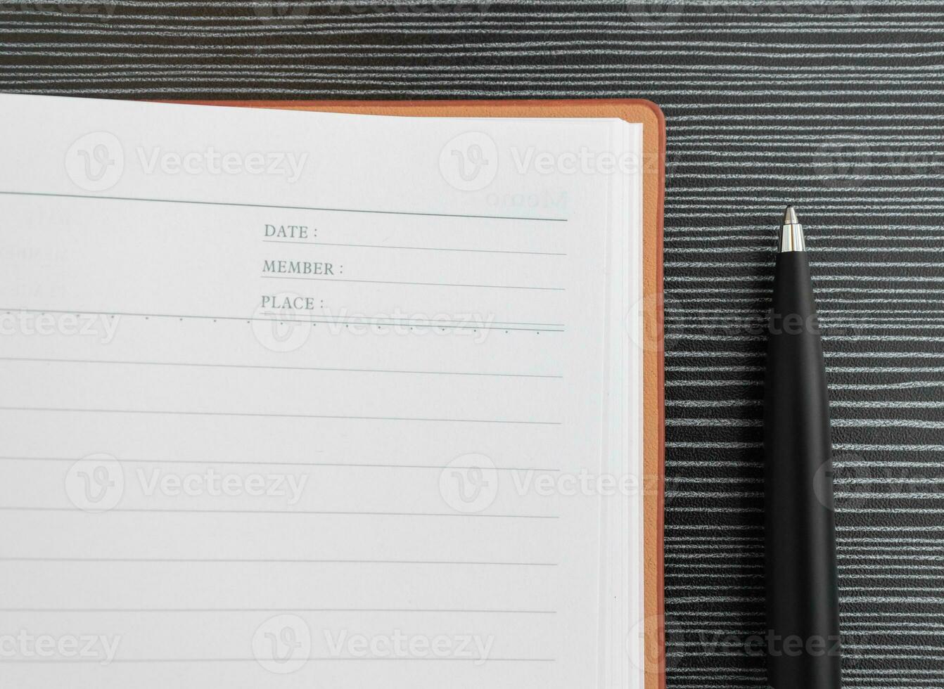 un bolígrafo y libro metido en texturizado mesa. después algunos ediciones foto