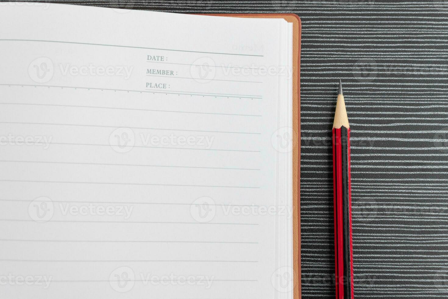 A pencil and book placed on textured table. After some edits. photo