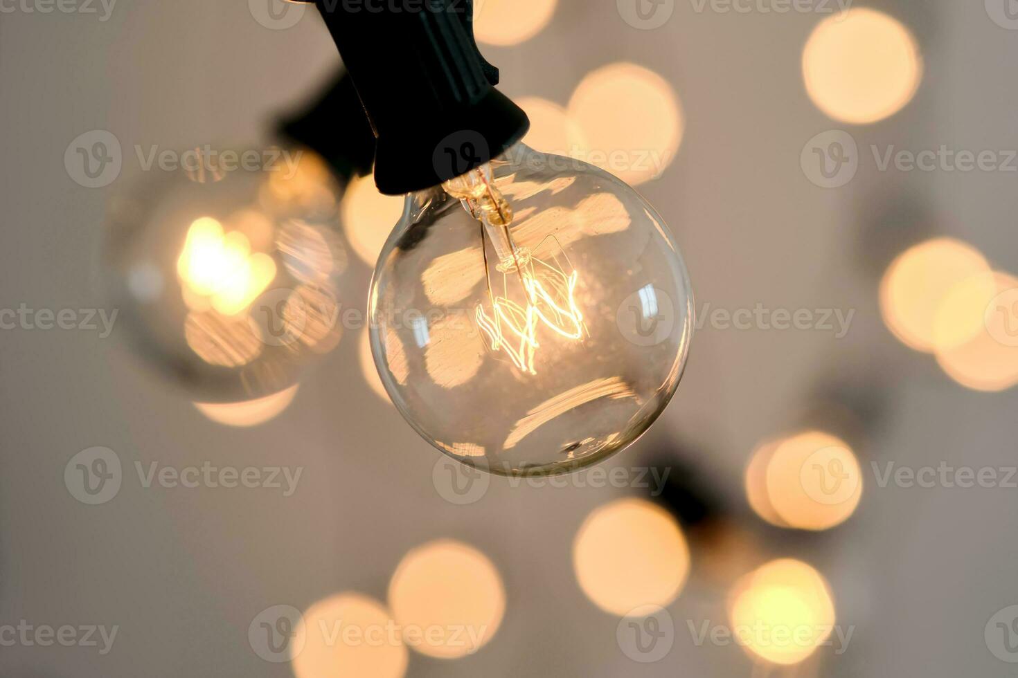 Incandescent light bulb with christmas round bokeh. photo