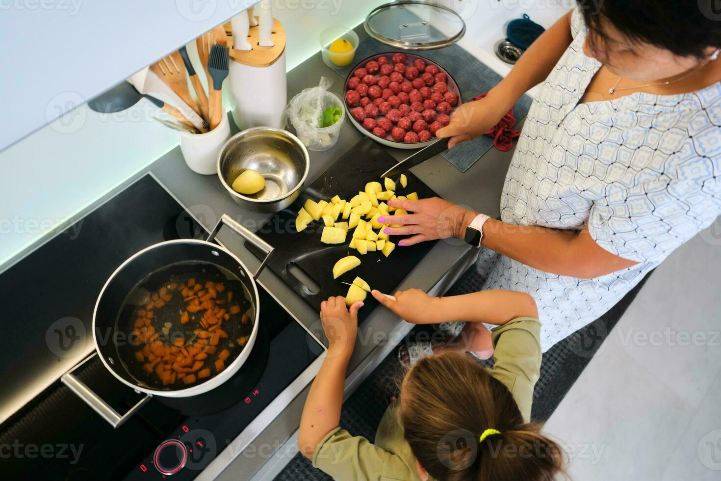 Grandmother and granddaughter are preparing soup. photo