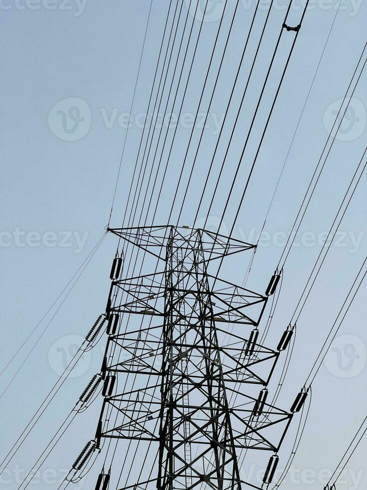 alto voltaje eléctrico torre en contra un claro azul cielo. alto, acero polo de poder líneas en contra el cielo. foto