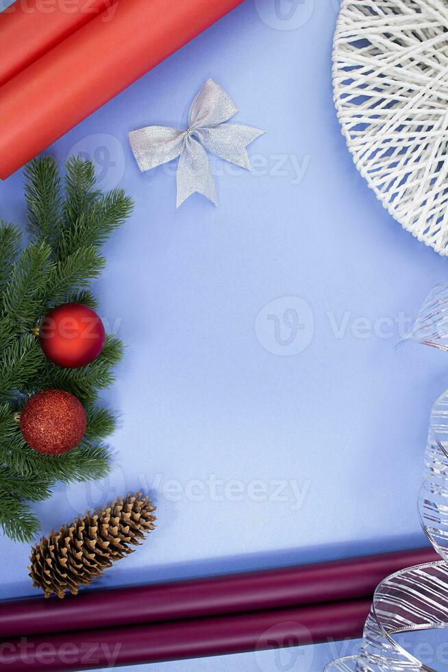 regalo rollos de papel, pino cono, arco y cinta, abeto ramas con Navidad pelotas en azul antecedentes. nuevo año Navidad. accesorios para regalo envase foto