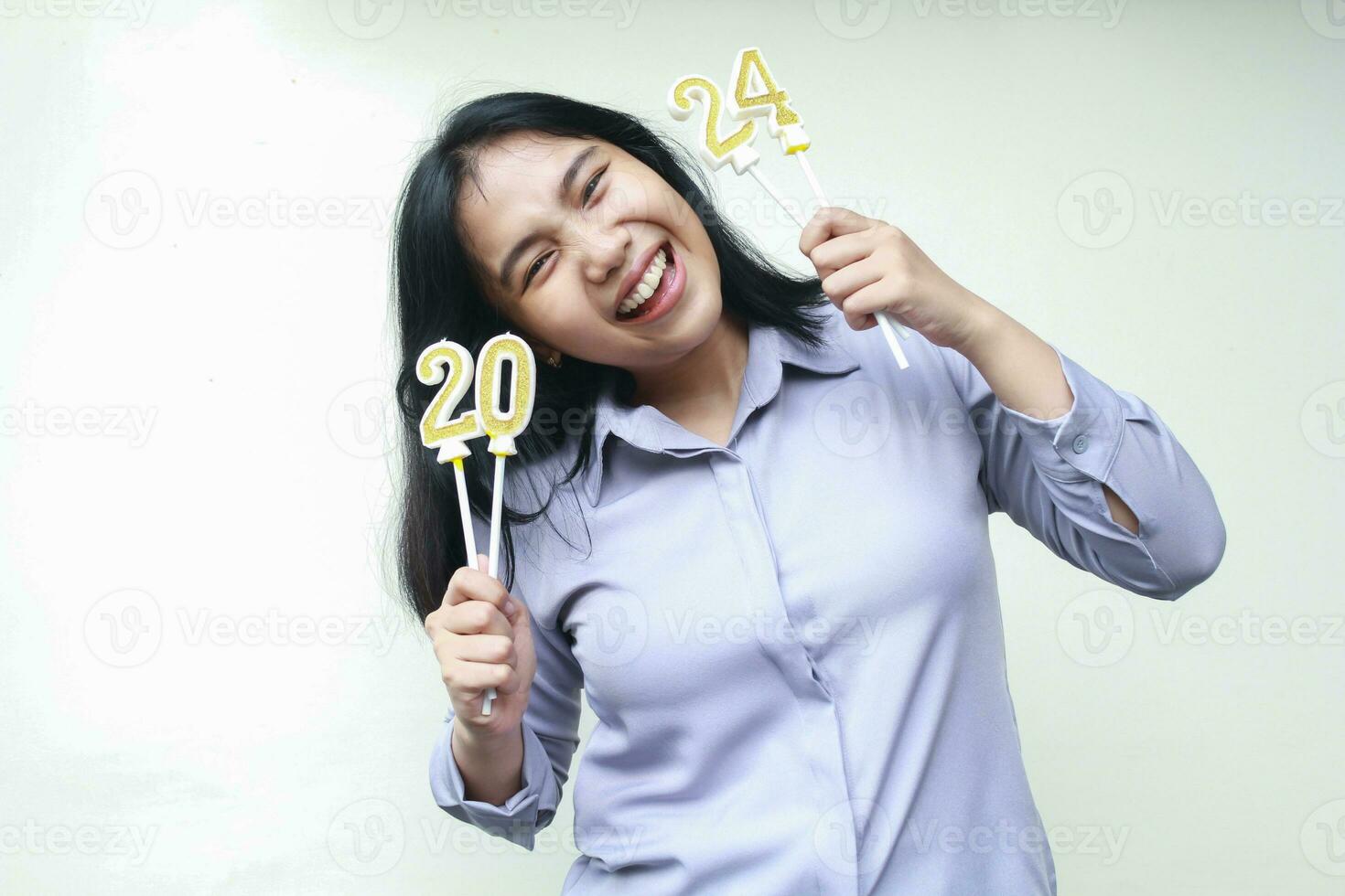 retrato de despreocupado asiático joven mujer sonriente a cámara con levantamiento brazo participación 2024 figura vela vistiendo gris formal traje, aislado en blanco, hembra gerente celebrando nuevo años víspera foto