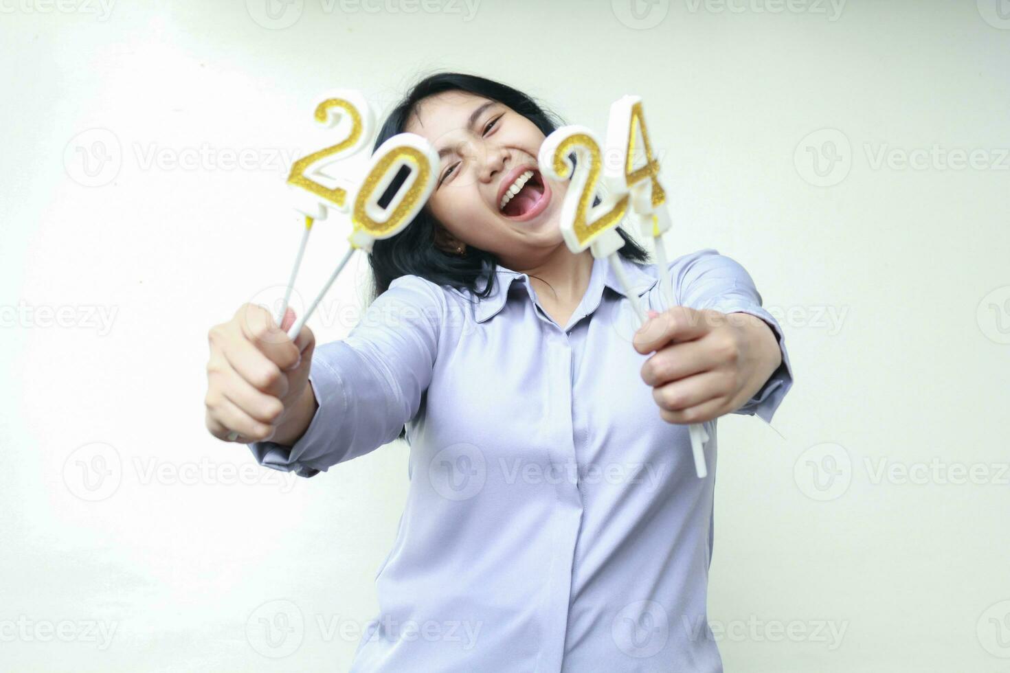 asiático joven negocio mujer riendo a cámara lleno de felicidad espectáculo 2024 número vela participación en mano, hembra compañero de trabajo vestir gris formal traje, aislado terminado blanco antecedentes foto