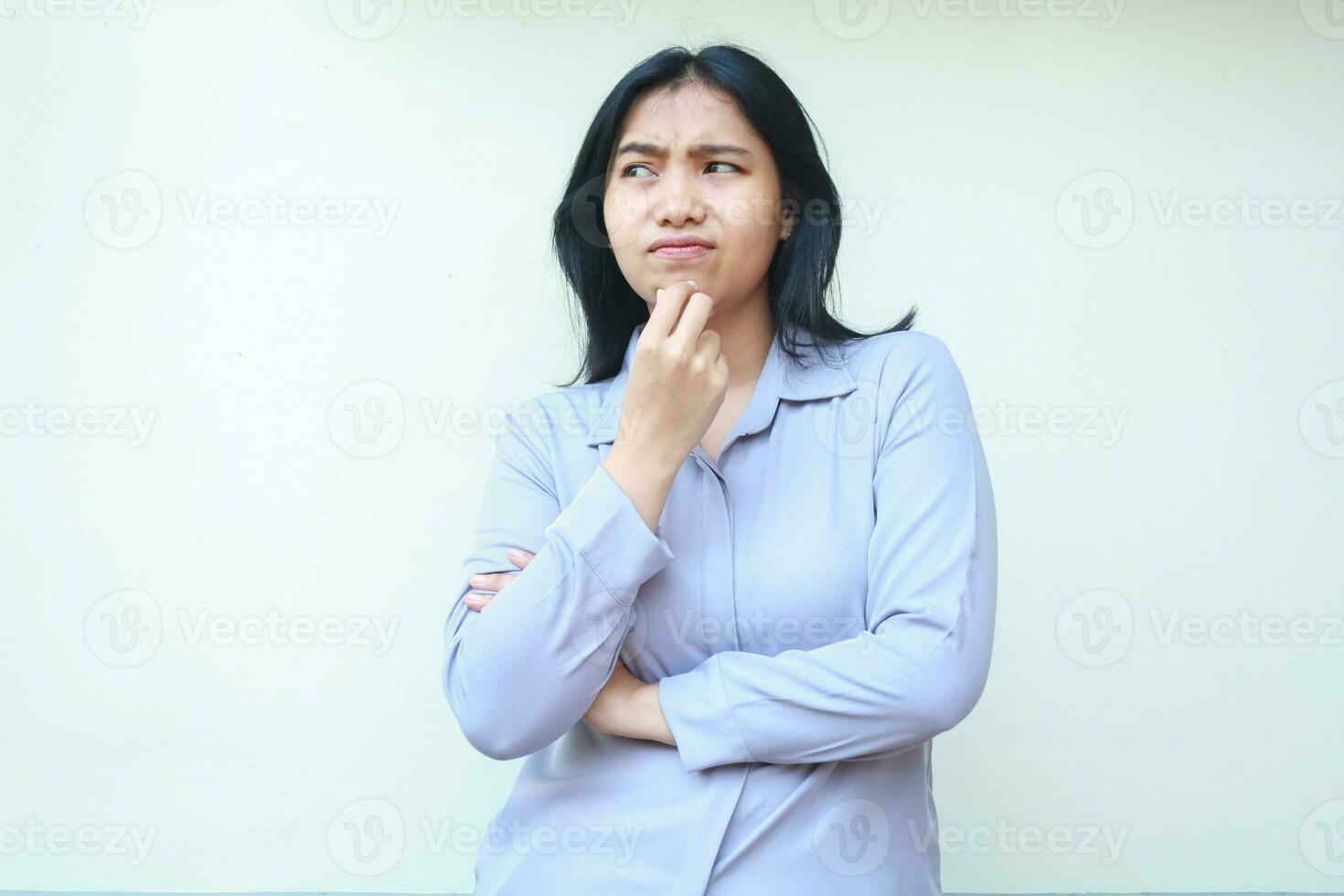 portrait of pensive beautiful asian woman looking away thinking something curious with hand touch her chin and folded arm wearing formal suit isolated over white background photo