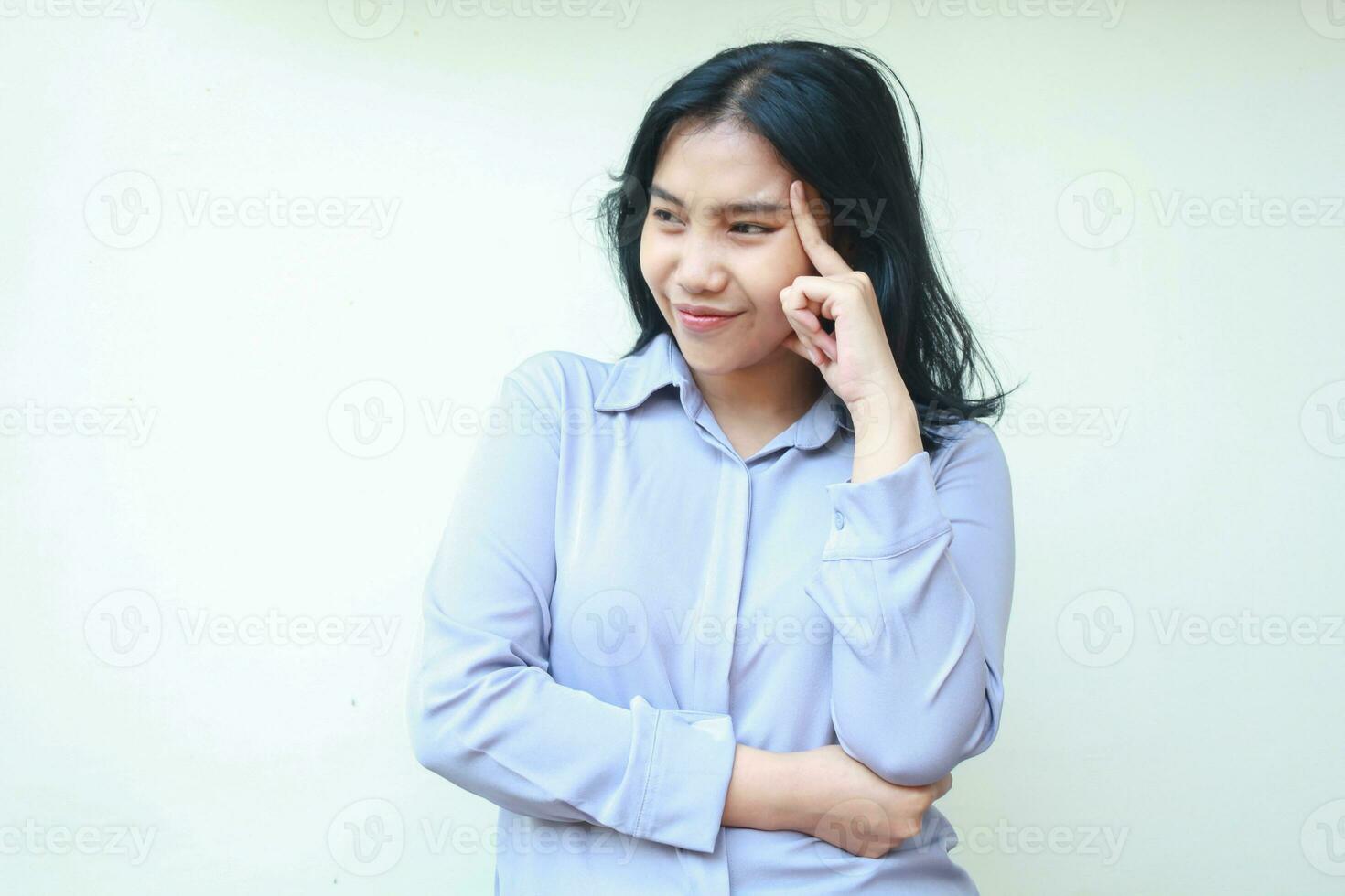 portrait of pensive asian woman thinking and pondering choice looking away and smiling with folded arm and touching her head isolated over white background photo