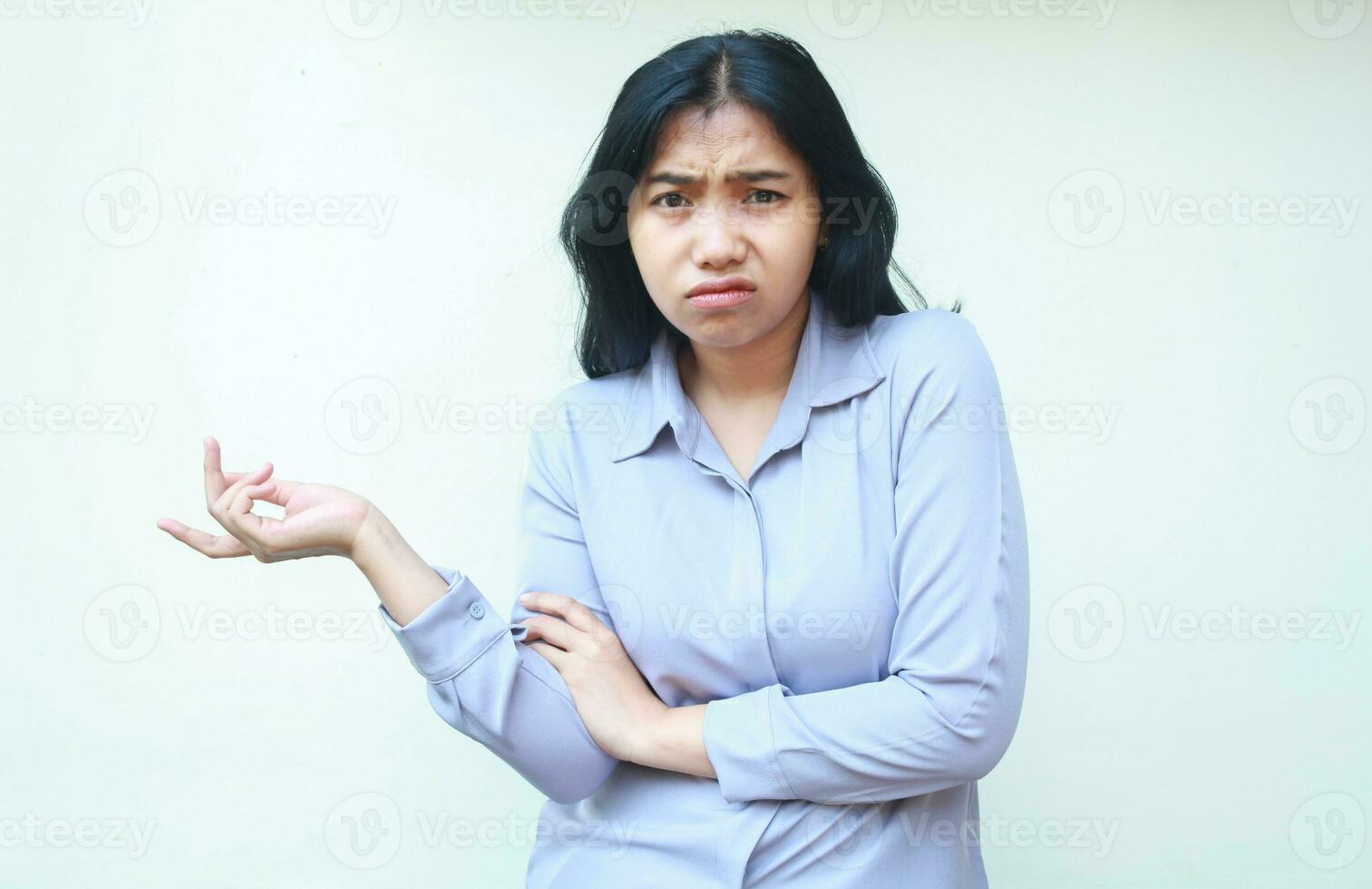 dissatisfied puzzled asian young business woman spreading palm and shrugging shoulders confused looking at camera isolated over white background photo